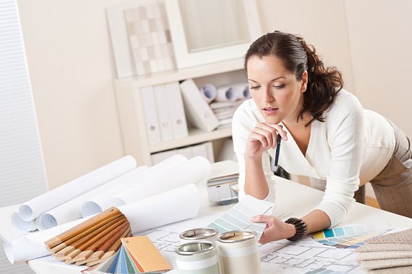 Female interior designer working at office with color swatch and paint