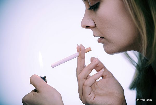 Young woman with lighter lighting up cigarette. Girl smoking.