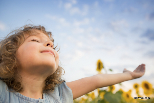 Happy child outdoors in spring sunflower field