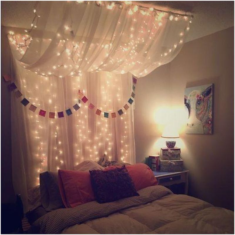 Queen-sized bed with hanging lights and canopy