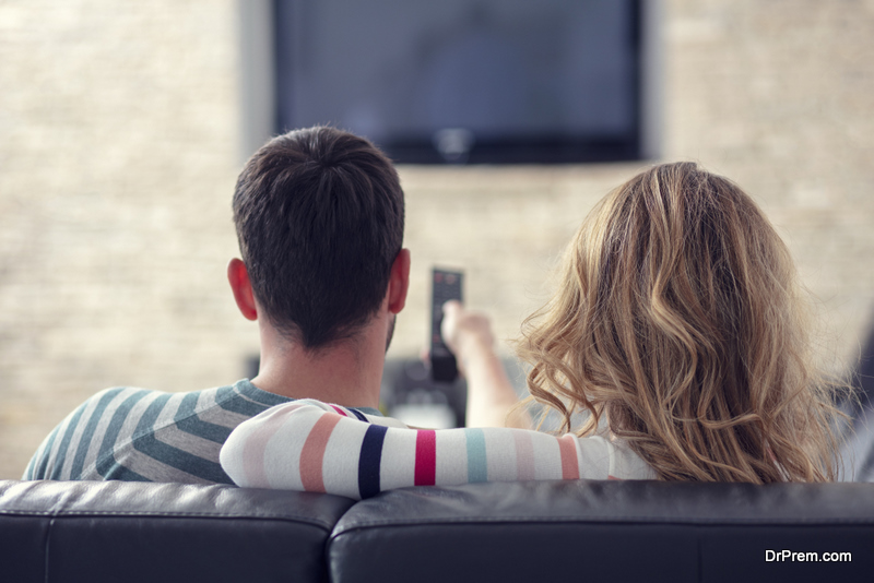 Happy-young-couple-relaxing-and-watching-TV-at-home