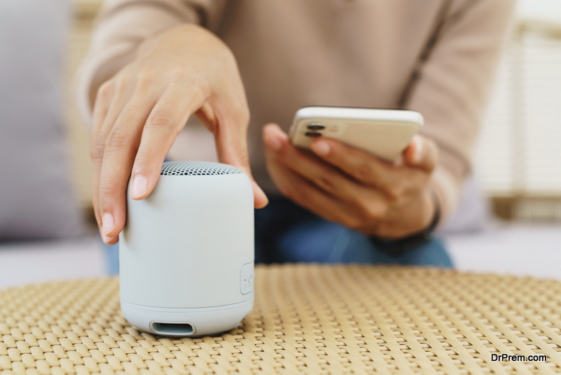 Close-up on hand using phone connecting speaker bluetooth