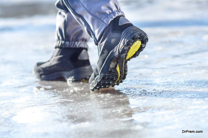 Winter legs wearing boots walking on snowy and sleet road