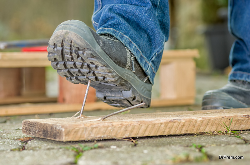 Worker with safety boots steps on a nail
