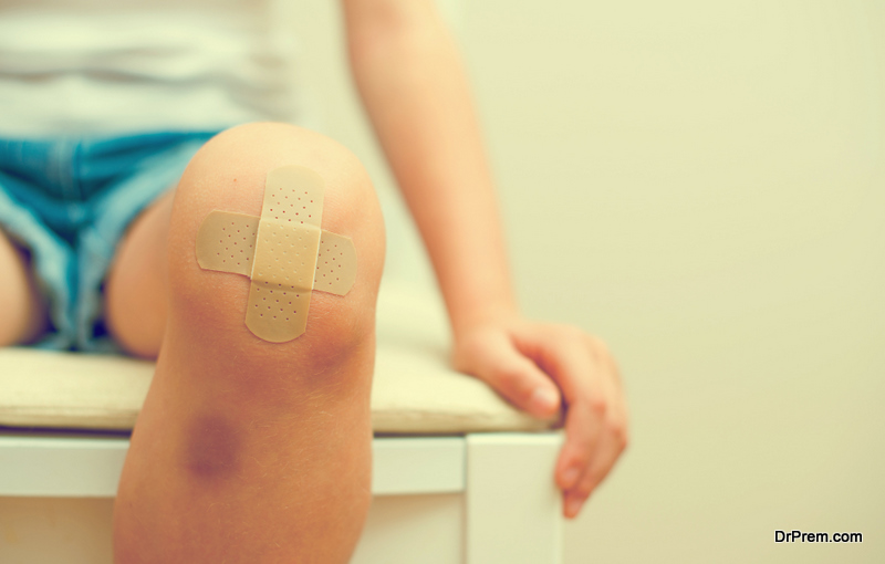 Child knee with an adhesive bandage and bruise
