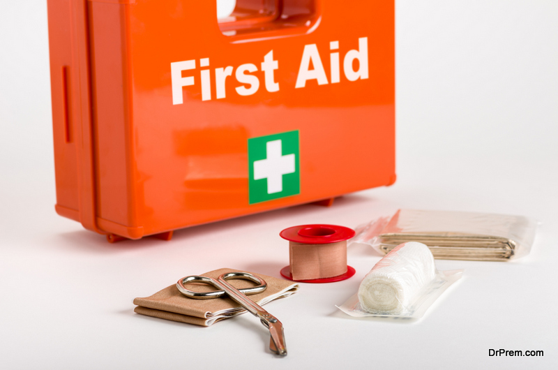 A red first aid box with supplies for dressings in front