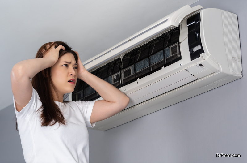 stressed young woman has problem with the air conditioner at home